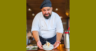 Portrait von Domenico, er zeigt knusprige Reisgalette mit geröstetem Rosenkohl, süss-saurem Teriyaki-Schaum und Katsuobushi