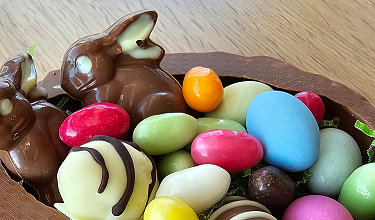 Kleine Ausstellung von Gebäck und Schokolade auf einem goldfarbenen Sideboard