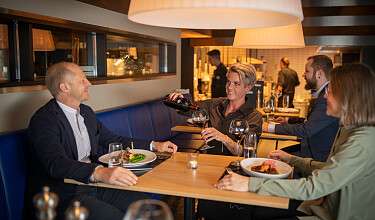 Scène de restaurant avec des personnes assises à table et savourant leur dîner