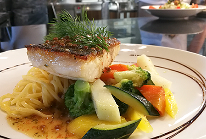 Poisson grillé avec légumes colorés joliment présenté sur assiette