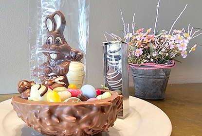 Schokoladen-Hase und -Ei mit frühlingshaftem Hintergrund